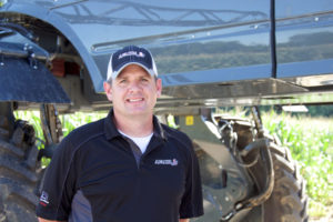 Adam Kivett in front of an Apache Sprayer